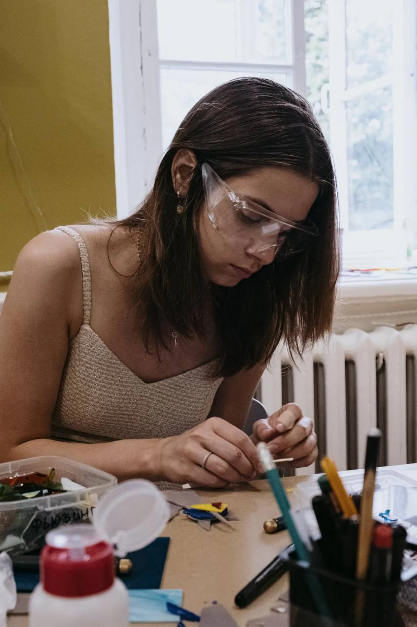 Мастер помогает участнице создать витраж в студии GlassBaker